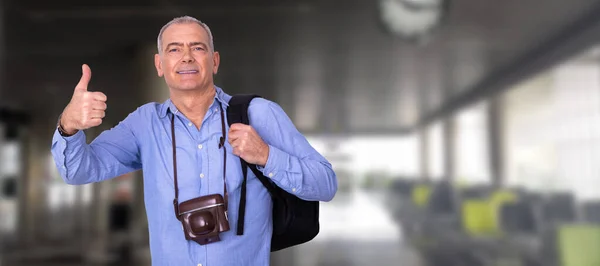 man with camera and luggage at the airport