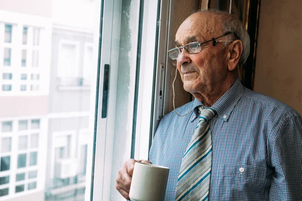 Homem Sênior Com Xícara Café Casa Olhando Pela Janela — Fotografia de Stock