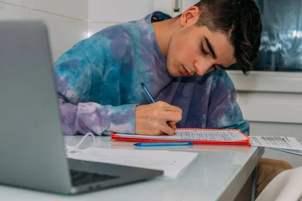 student at the table writing and studying