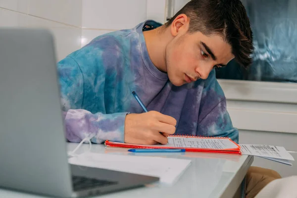 student at the table writing and studying