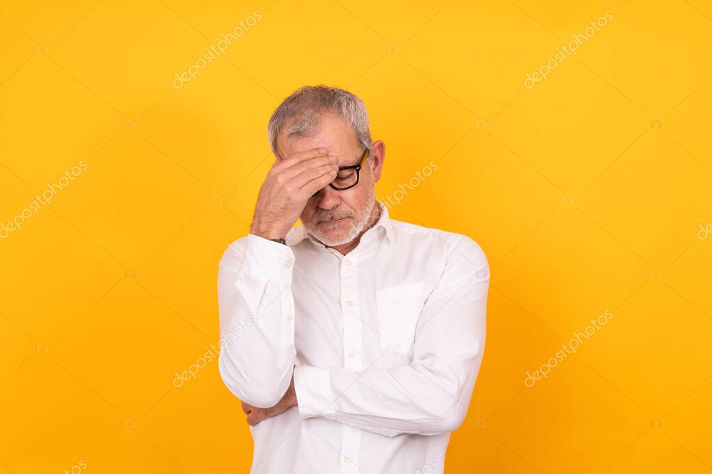 desperate senior adult man with hand on head isolated