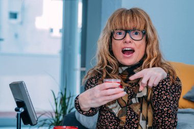 Evde cep telefonuyla kozmetik ürünleri gösteren etken