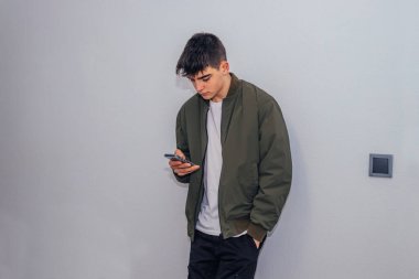 Ev duvarında cep telefonu olan genç çocuk izole edilmiş.