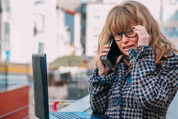 Sokakta Dizüstü Bilgisayarı Olan Bir Kadın Cep Telefonuyla Konuşuyor — Stok fotoğraf