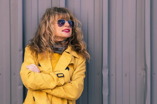 Attraente Donna Bionda Occhiali Sole Impermeabile Giallo Sul Muro Della — Foto Stock