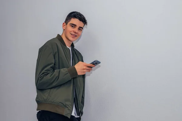 Teenager Chlapec Mobilním Telefonem Domácí Zdi Izolované — Stock fotografie