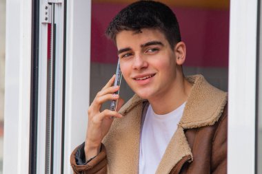 Delikanlı terasta cep telefonuyla mı konuşuyor yoksa akıllı telefonuyla mı?