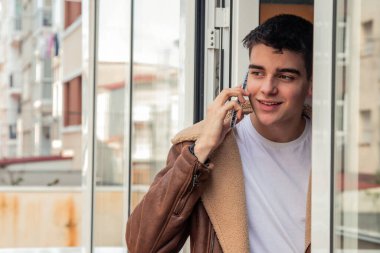 Delikanlı terasta cep telefonuyla mı konuşuyor yoksa akıllı telefonuyla mı?