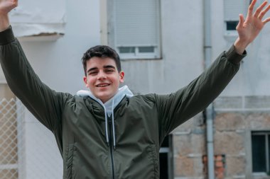 Mutlu genç adam dışarıda kutlama yapıyor.