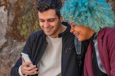 Gülümseyen çift cep telefonuna bakıyor