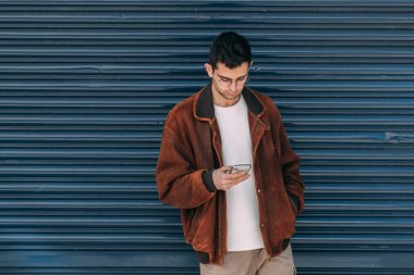 Şehirdeki telefon ve maskeli genç adam.