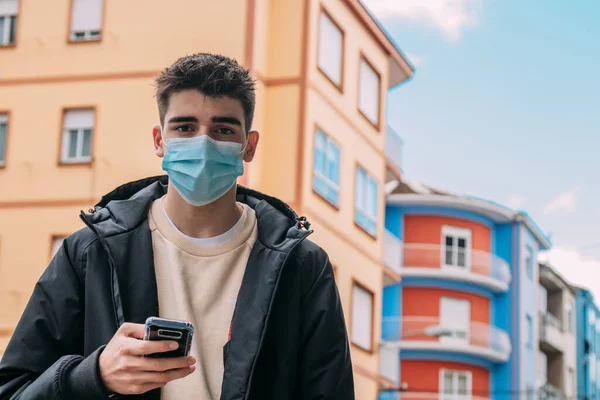 young man with phone and mask in the city