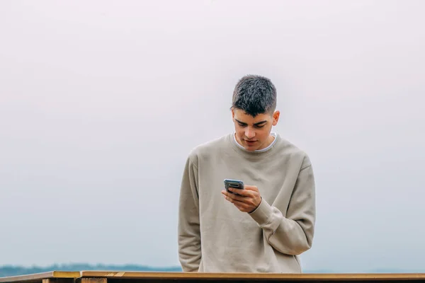 Young Teenager Using Mobile Phone Outdoors — Stockfoto