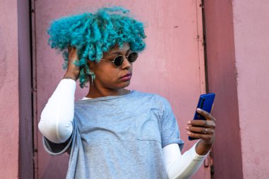 Sokakta cep telefonu olan bir kadın fotoğraf çekiyor.