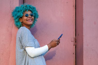 Siyah saçlı ve cep telefonlu Afro-Amerikalı kız.