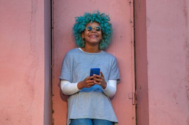 Sokakta cep telefonu olan Afro-Amerikan hippi kız.