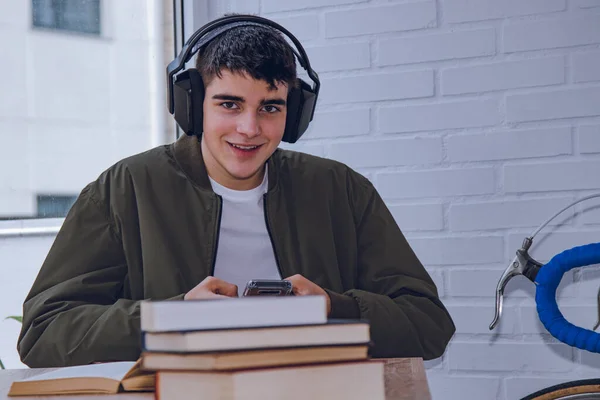 student at home with headphones and mobile phone