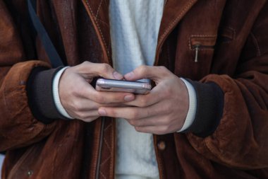 Cep telefonunda yazan ellerin yakın plan görüntüsü