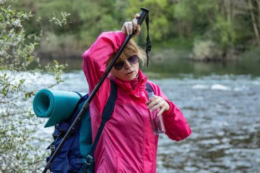 Sırt çantalı, içme suyu olan bir kadın.