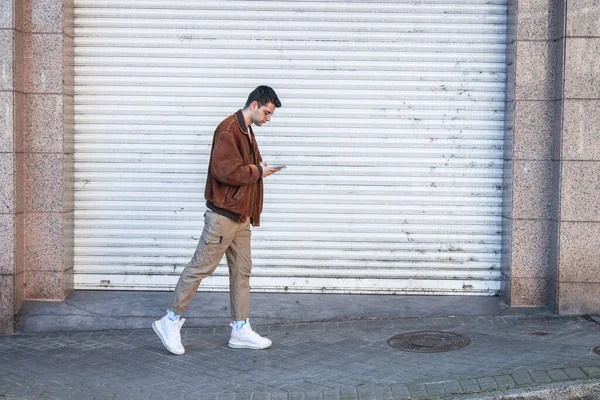 Jovem Caminhando Rua Olhando Para Telefone Celular — Fotografia de Stock