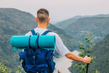 Sırt çantalı gezgin manzaraya bakıyor.