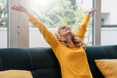 Evdeki kanepede mutlu bir kadın.