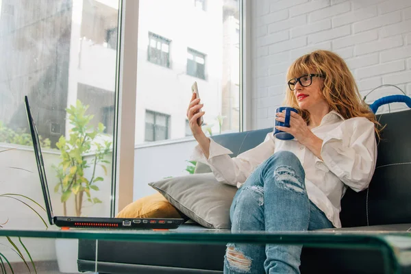 Mujer Sofá Casa Con Computadora Del Teléfono Móvil Taza — Foto de Stock