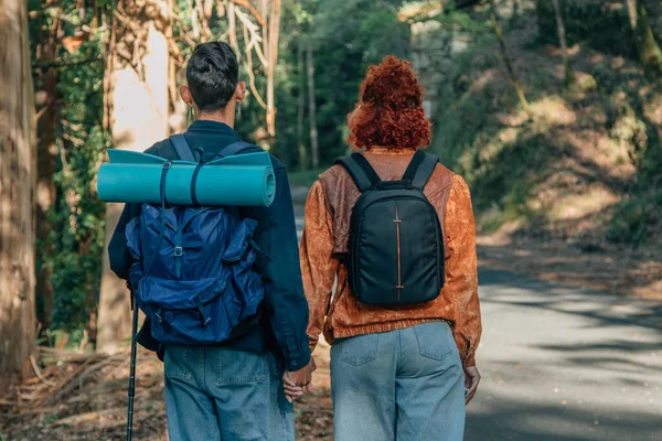 young couple with backpacks outdoor travel back to back
