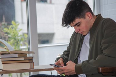 young student at the desk with mobile phone
