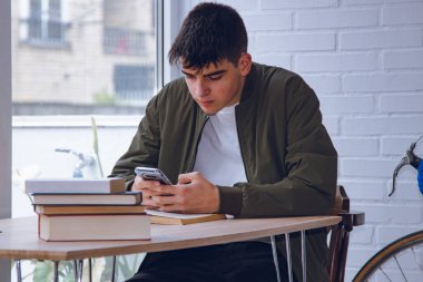 young student at the desk with mobile phone