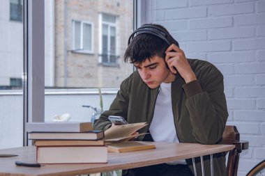 student with mobile phone and headphones at the desk