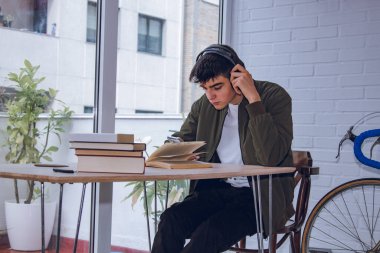 student with mobile phone and headphones at the desk