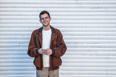 Sokaktaki cep telefonlu genç adamın portresi.