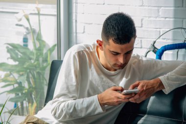 Evde cep telefonu olan bir adam.
