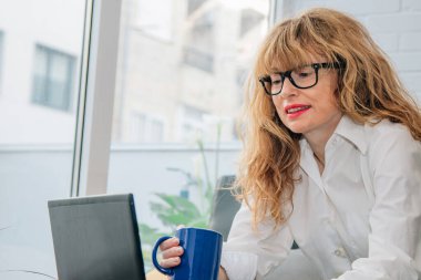 Evde cihazla çalışan orta yaşlı bir kadın