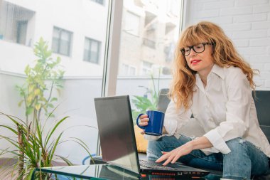 Evde cihazla çalışan orta yaşlı bir kadın