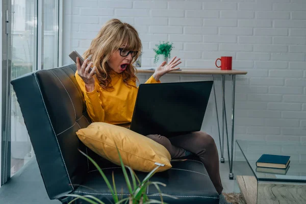 Förvånad Kvinna Med Mobiltelefon Och Dator Hemma — Stockfoto