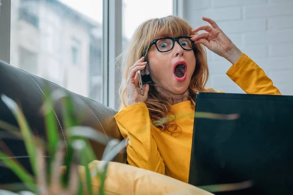 Kvinna Med Mobiltelefon Och Dator Med Ett Överraskande Uttryck — Stockfoto