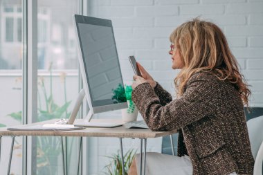 Cep telefonu ve bilgisayarı olan iş kadını