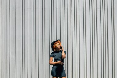 Afrika kökenli Amerikalı kız cep telefonuyla konuşuyor. Mesaj ya da kopya için geçmişi var.