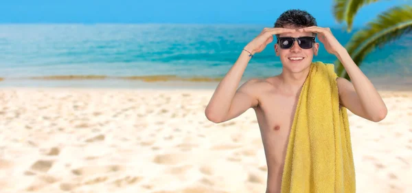 ビーチにタオルとサングラスを持った10代の男の子 — ストック写真