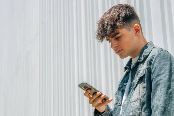 Tiener Jongen Zoek Naar Mobiele Telefoon — Stockfoto