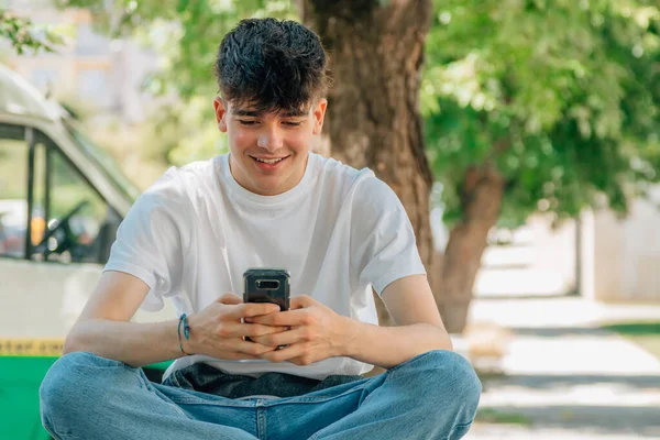 Masculino Adolescente Sentado Rua Com Telefone Celular — Fotografia de Stock
