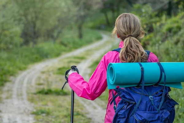 middle-aged woman with backpack while hiking or on pilgrimage