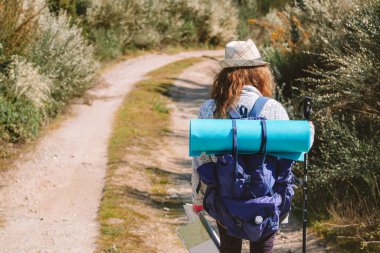 Sırt çantalı bir kadın. Yürürken veya hacca giderken.