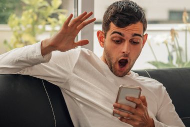 Evdeki adam cep telefonuna bakarken şaşırdı.