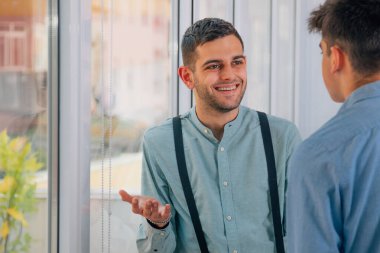 genç girişimciler ofiste ya da çalışma alanında konuşuyor ya da tartışıyorlar