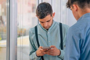 Ofiste cep telefonlu genç işçiler