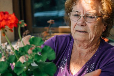 Bitkilerle ilgilenen yaşlı kadın.