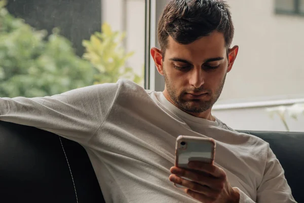 Hombre Casa Sentado Sofá Con Teléfono Móvil — Foto de Stock